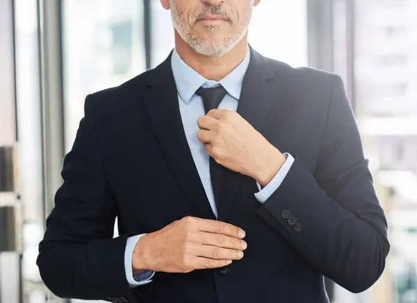 Připraven na všechno ve světě korporací. Detailní záběr zralého podnikatele narovnává kravatu, když stojí v kanceláři. — Stock fotografie
