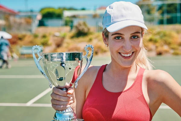 Ich habe es geschafft. Ausgeschnittenes Porträt einer attraktiven jungen Frau, die eine Trophäe hochhält, nachdem sie tagsüber ein Tennismatch gewonnen hat. — Stockfoto