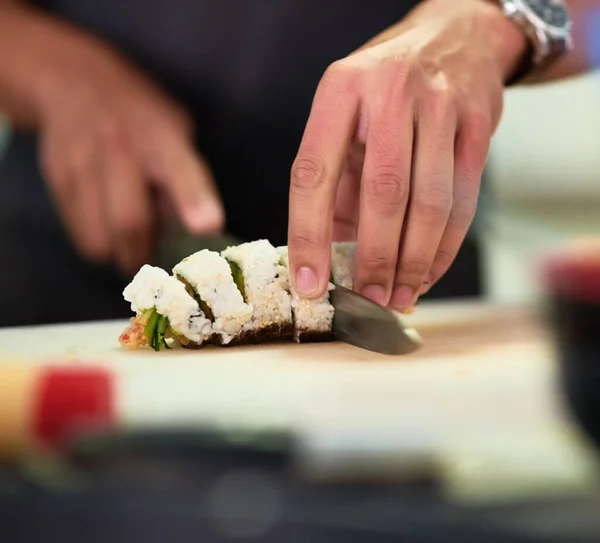 Parece bom o suficiente para comer. Tiro de um jovem não identificável preparando sushi em sua cozinha. — Fotografia de Stock