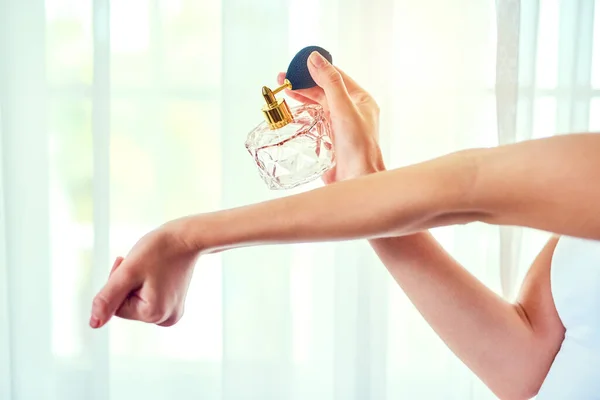 Perfume - um acessório invisível, mas inesquecível. Foto de perto de uma mulher irreconhecível aplicando perfume em seus pulsos. — Fotografia de Stock