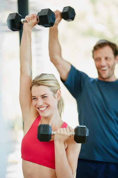Fitness in eigen hand nemen. Gehakt schot van een sportief paar samen aan het trainen thuis. — Stockfoto