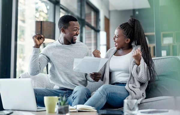 Nada se sente melhor do que estar livre de dívidas. Tiro de um jovem casal comemorando enquanto passava pela papelada em casa. — Fotografia de Stock