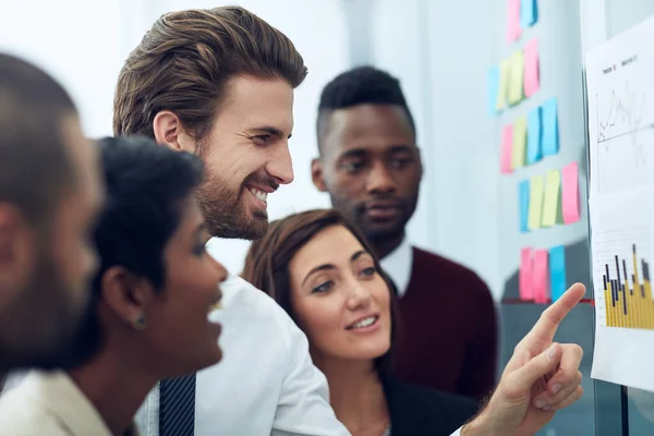 Mirando algunos números positivos. Recorte de un grupo de colegas que trabajan en la junta de ideas. — Foto de Stock