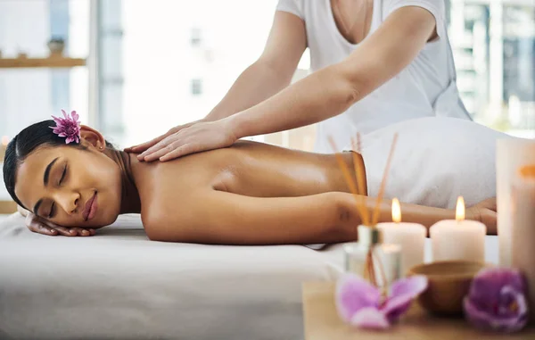Póngase primero y reserve ese masaje. Fotografía de una joven atractiva recibiendo un masaje en un spa. — Foto de Stock