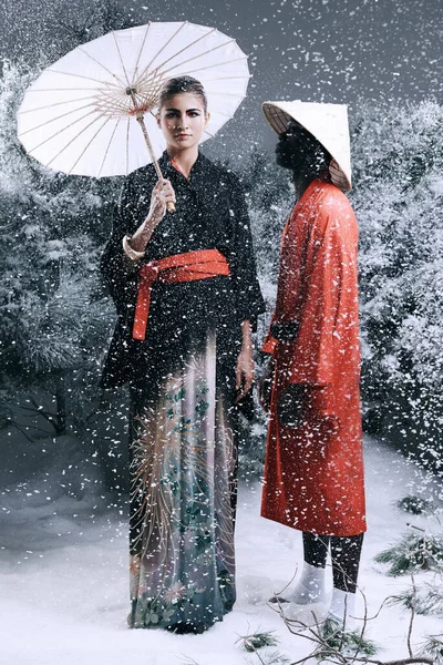 Conto de fadas da moda. Moda tiro de um homem e mulher vestindo roupas de estilo oriental em uma floresta nevada. — Fotografia de Stock