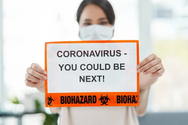 C'est un problème mondial qui appelle une réponse mondiale. Prise de vue d'une femme tenant une pancarte disant CORONAVIRUS - VOUS POURRIEZ ÊTRE PROCHAINE. — Photo