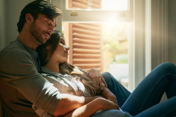 Cada momento compartido contigo se siente como una eternidad. Fotografía de una joven pareja cariñosa abrazándose en casa a la luz del sol. —  Fotos de Stock