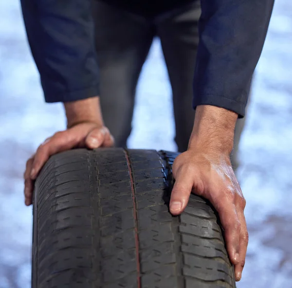 Vyrovnejme to kolo. Vysoký úhel záběru nerozpoznatelného mechanika, který projíždí pneumatiku dílnou během servisu. — Stock fotografie