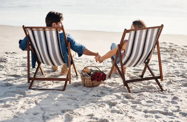 Qui per le onde dell'oceano e le giornate pigre. Retrovisore di una coppia di mezza età seduta sulle loro sedie sulla spiaggia. — Foto Stock