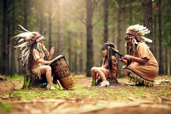 Sie spielen das Lied ihres Volkes. Aufnahme einer jungen Frau und ihrer beiden Töchter beim Dressup im Wald. — Stockfoto