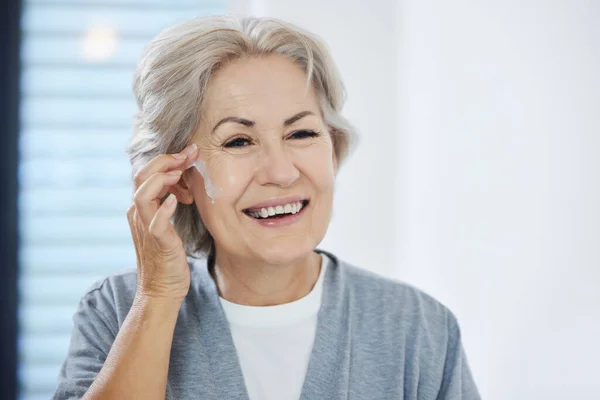 Questo mi fa sembrare giovane. Girato di una donna anziana che passa attraverso la sua routine di cura della pelle a casa. — Foto Stock