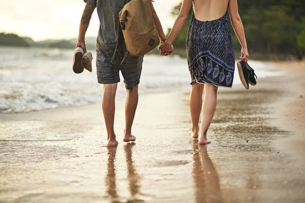 A passear ao pôr-do-sol. Tiro cortado de um casal não identificável de mãos dadas enquanto caminhava pela praia. — Fotografia de Stock