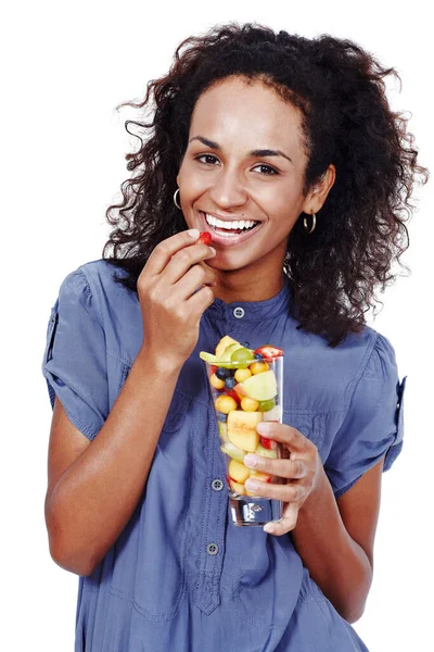 Faz bem ao meu corpo. Estúdio retrato de uma mulher sorridente comendo salada de frutas isolada em branco. — Fotografia de Stock
