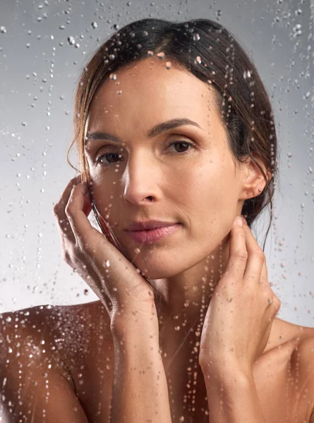 Sentirse totalmente fresco y seguro. Retrato de estudio de una hermosa joven tomando una ducha sobre un fondo gris. —  Fotos de Stock