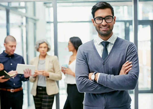 És tão bom como a equipa que te apoia. Retrato de um homem de negócios em pé em um escritório com seus colegas em segundo plano. — Fotografia de Stock
