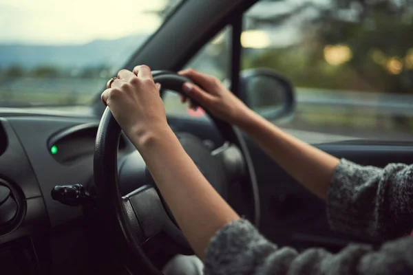 Mains sur le volant. Coupé coup d'une femme méconnaissable conduisant sa voiture. — Photo