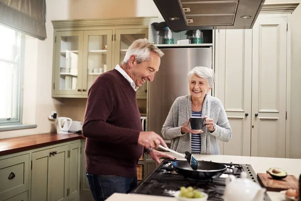 Preparándose para cocinar su comida favorita. Toma de una cariñosa pareja de ancianos cocinando juntos en su cocina en casa. — Foto de Stock