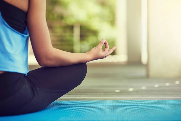 Yoga är livets väg. Beskuren bild av en ung kvinna som sitter i lotusställning. — Stockfoto