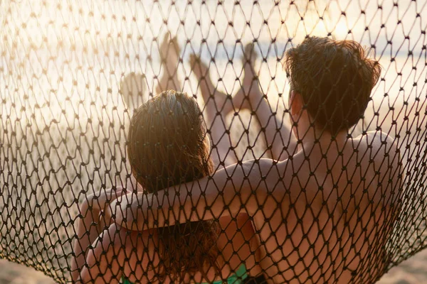 Refroidissement à la plage. Vue arrière prise d'un jeune couple se relaxant sur un hamac à la plage. — Photo