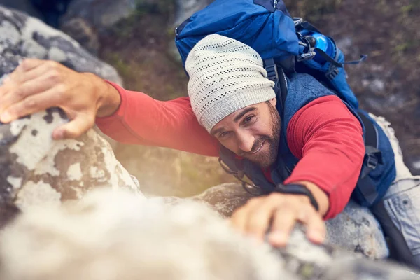 O que não te mata torna-te mais forte. Tiro de um caminhante feliz escalando rochas em uma trilha de montanha. — Fotografia de Stock