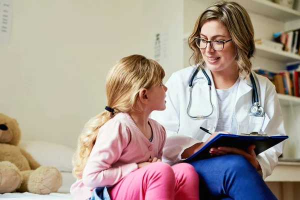 Het behoud van de gezondheid van kinderen is een lonende ervaring. Shot van een arts met een consult met een klein meisje in haar spreekkamer. — Stockfoto