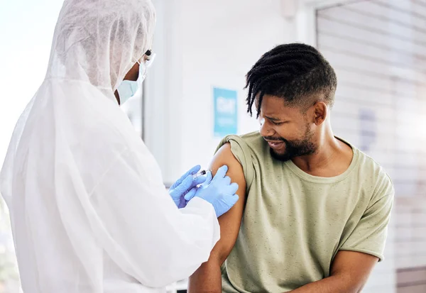 자 압 만있으면 됩니다. 잘생긴 젊은 남성 환자에게 19 개의 백신을 투여하고 있는 알아볼 수없는 의사의 총에 맞은 사진. — 스톡 사진
