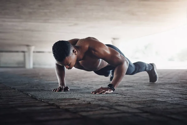 Hes one strong man. Full length shot of a handsome young man doing pushups while exercising outside. — Stock Photo, Image