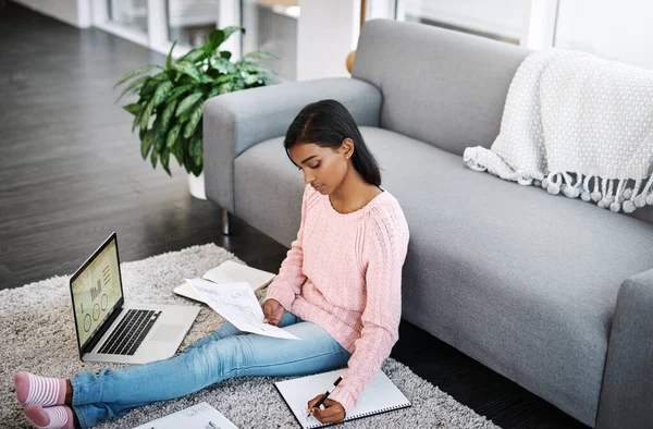 Víkend může být také pro práci. Snímek mladé krásné ženy pomocí notebooku a prochází papírování, zatímco sedí na podlaze v obývacím pokoji doma. — Stock fotografie
