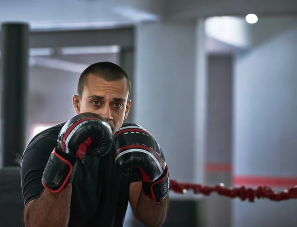 Pracuju na jeho formuláři. Zastřižený portrét mladého sportovce trénujícího v boxerském ringu. — Stock fotografie