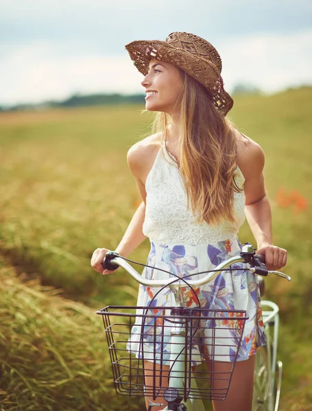 Es un mundo hermoso, sal y descúbrelo. Fotografía de una joven en bicicleta por el campo. — Foto de Stock