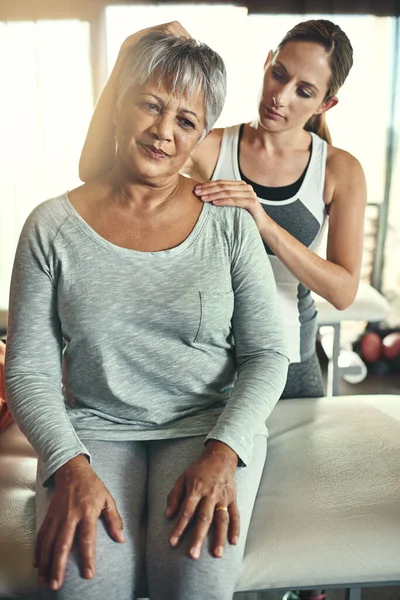 Erlauben Sie mir, den Druck zu nehmen. Aufnahme einer Seniorin, die von einem Physiotherapeuten behandelt wird. — Stockfoto
