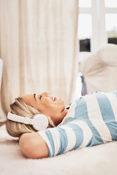 Hoy es casi escalofriante. Fotografía de una joven escuchando música mientras se relaja en casa. — Foto de Stock