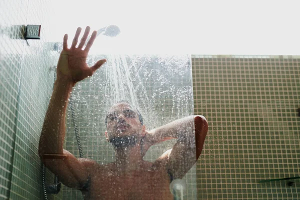 The shower is a great place to cool off. Cropped shot of a handsome young man having a refreshing shower at home. — Stock Photo, Image