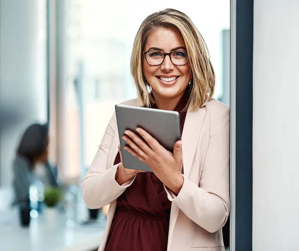 La tecnología ayuda a nivelar mi éxito. Retrato de una empresaria confiada usando una tableta digital en una oficina. —  Fotos de Stock