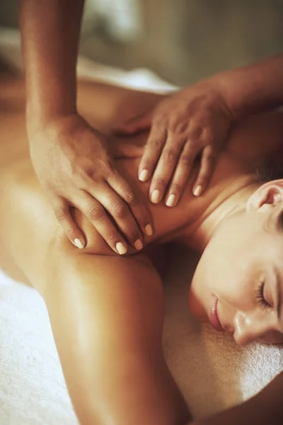 Não fica mais relaxante.... Tiro de uma jovem mulher desfrutando de uma massagem nas costas. — Fotografia de Stock