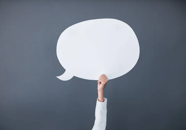 Express your message on here. Studio shot of an unrecognizable businesswoman holding up a white speech bubble against a gray background. — Stock Photo, Image