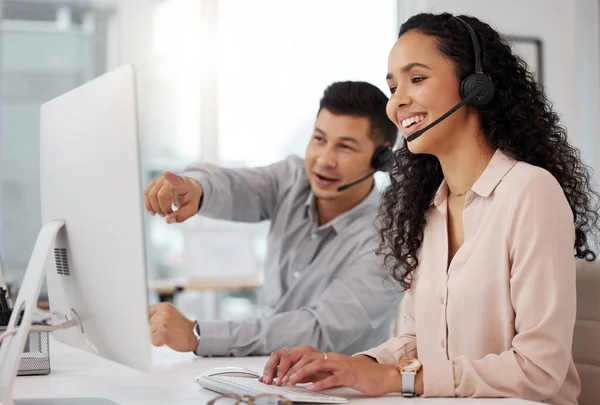 Compartilhar conselhos sobre como melhorar seus serviços. Tiro de dois agentes de call center trabalhando juntos em um computador em um escritório. — Fotografia de Stock