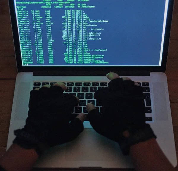 Su red ha sido violada. Fotografía de un hacker irreconocible usando un portátil en la oscuridad. — Foto de Stock