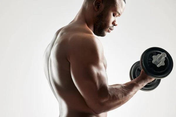 Overwin je mentale wegversperring en geef nooit op. Studio shot van een jonge man uit te werken met een halter tegen een grijze achtergrond. — Stockfoto