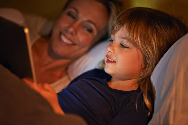 Cieszymy się razem przed snem. Matka i córka leżące w łóżku z tabletem cyfrowym. — Zdjęcie stockowe