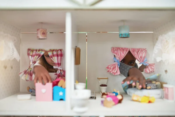 Dare alle loro bambole un posto da chiamare casa. Colpo ritagliato di due amici che giocano insieme con una casa delle bambole. — Foto Stock