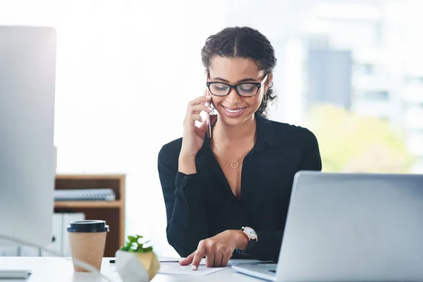 Ik bel klanten om ze goed op de hoogte te houden. Shot van een jonge zakenvrouw praten op een mobiele telefoon tijdens het werken in een kantoor. — Stockfoto