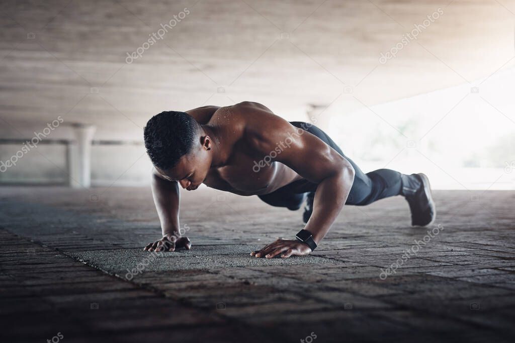 Hes one strong man. Full length shot of a handsome young man doing pushups while exercising outside.