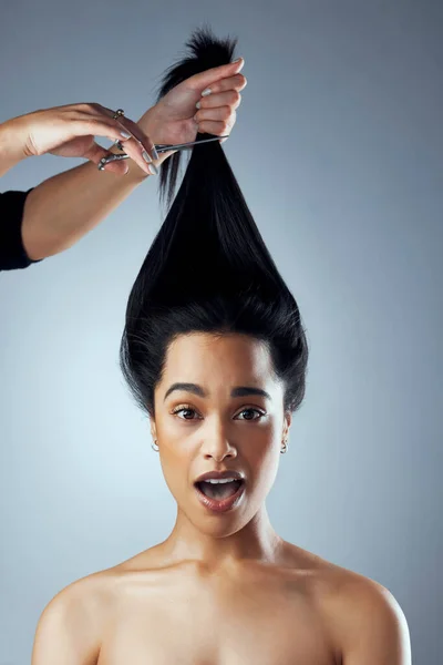 Elle va changer de vie. Plan studio de jeune femme se faisant couper les cheveux sur un fond gris. — Photo