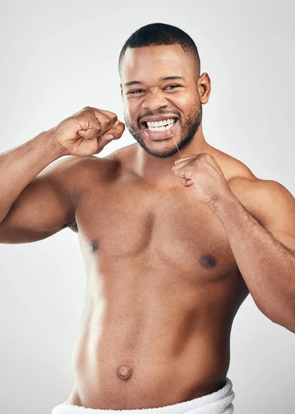 Cuida más tu sonrisa. Retrato del estudio de un joven guapo usando hilo dental sobre un fondo blanco. — Foto de Stock