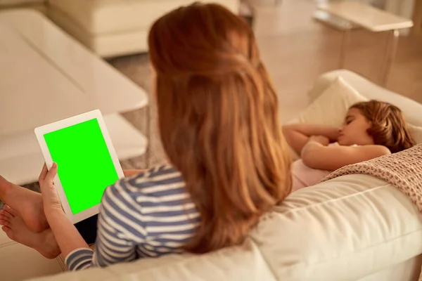 Tempo online e in famiglia - il meglio di entrambi i mondi. Colpo di madre che usa il tablet a casa mentre sua figlia dorme. — Foto Stock