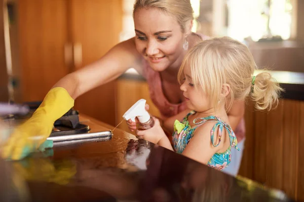 Zaangażowanie dzieci w pomoc w domu. Ujęcie matki i córki sprzątających razem kuchnię. — Zdjęcie stockowe
