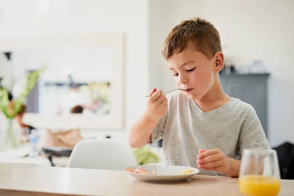 Começando o dia da forma nutricional. Tiro de um menino adorável tomando café da manhã em casa. — Fotografia de Stock