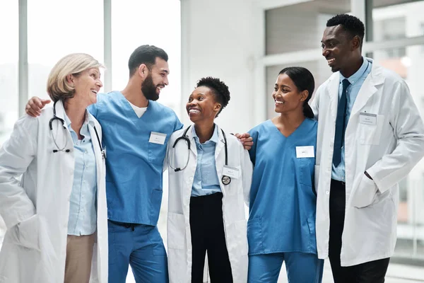 Promover a excelência em saúde como uma equipe dedicada. Tiro de um grupo de médicos de pé juntos em um hospital. — Fotografia de Stock