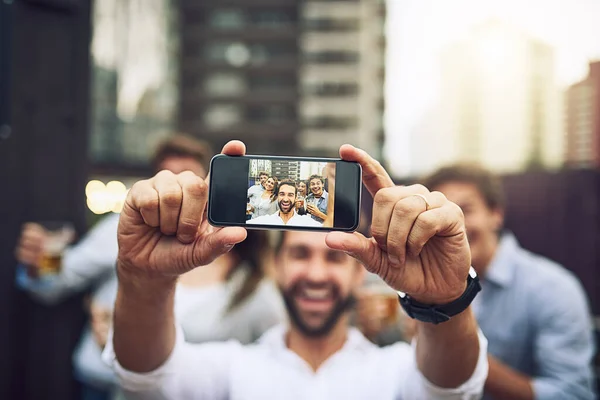 Temos de tirar uma foto juntos. Retrato de um grupo de jovens colegas de trabalho alegres fazendo um auto-retrato juntos fora durante o dia. — Fotografia de Stock